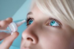 woman putting in eye drops